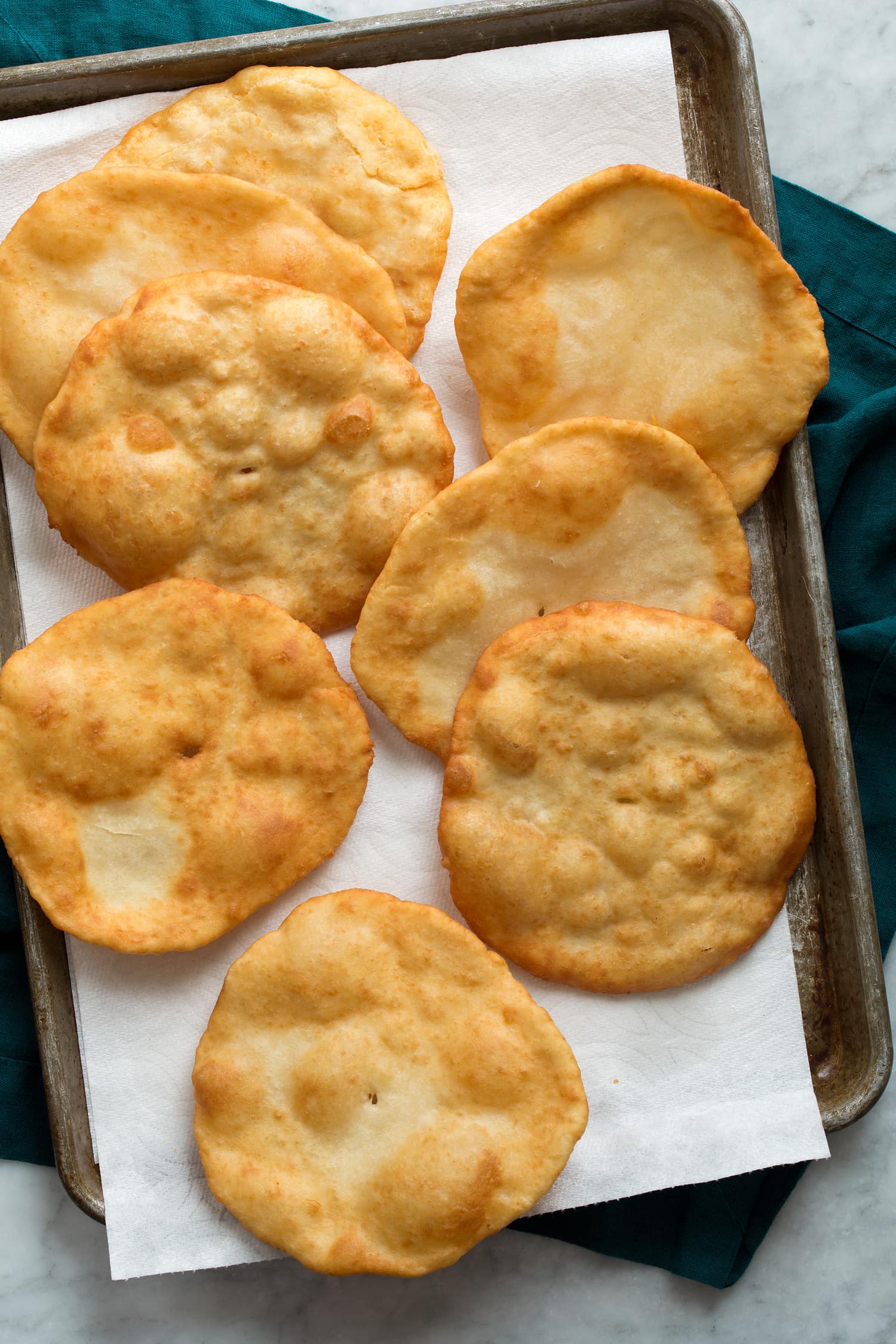 Fry Bread Overhead photo of fry bread draining on paper towel lined baking dish.