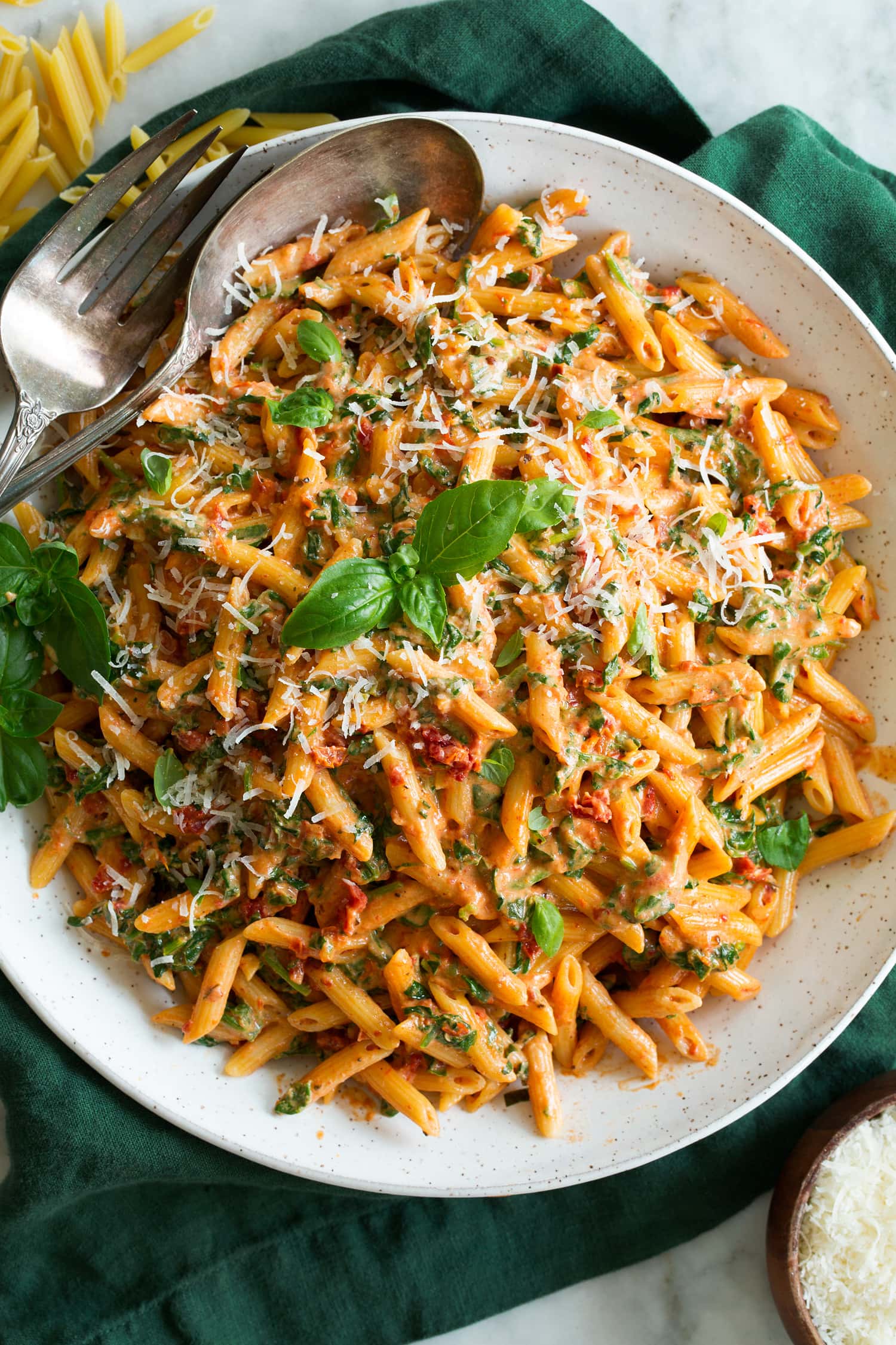 Sun Dried Tomato Pasta Sun Dried Tomato Pasta with creamy sauce shown in a white ceramic bowl over a green cloth.