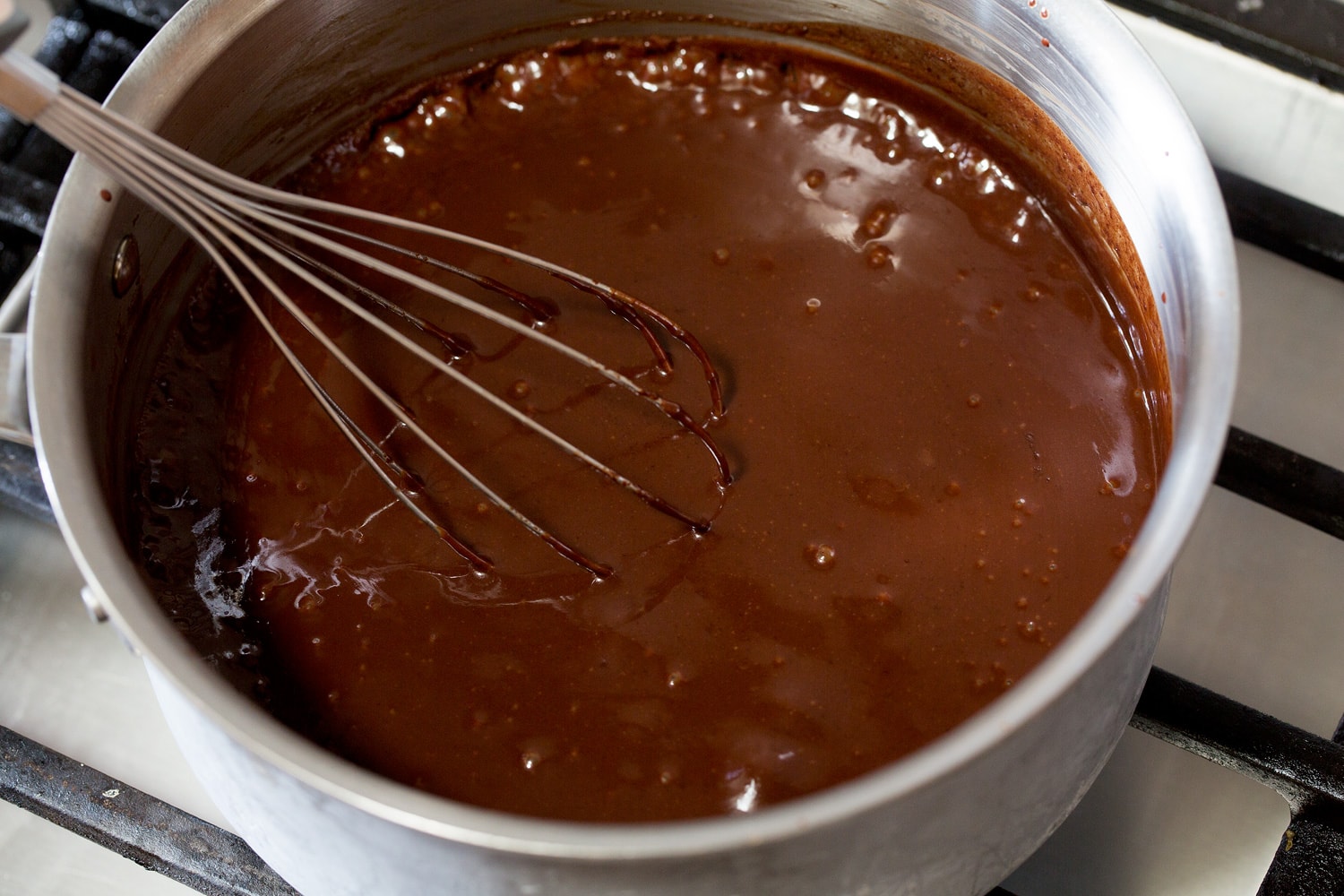 Hot Fudge Sauce Simmering ice cream fudge sauce in saucepan.