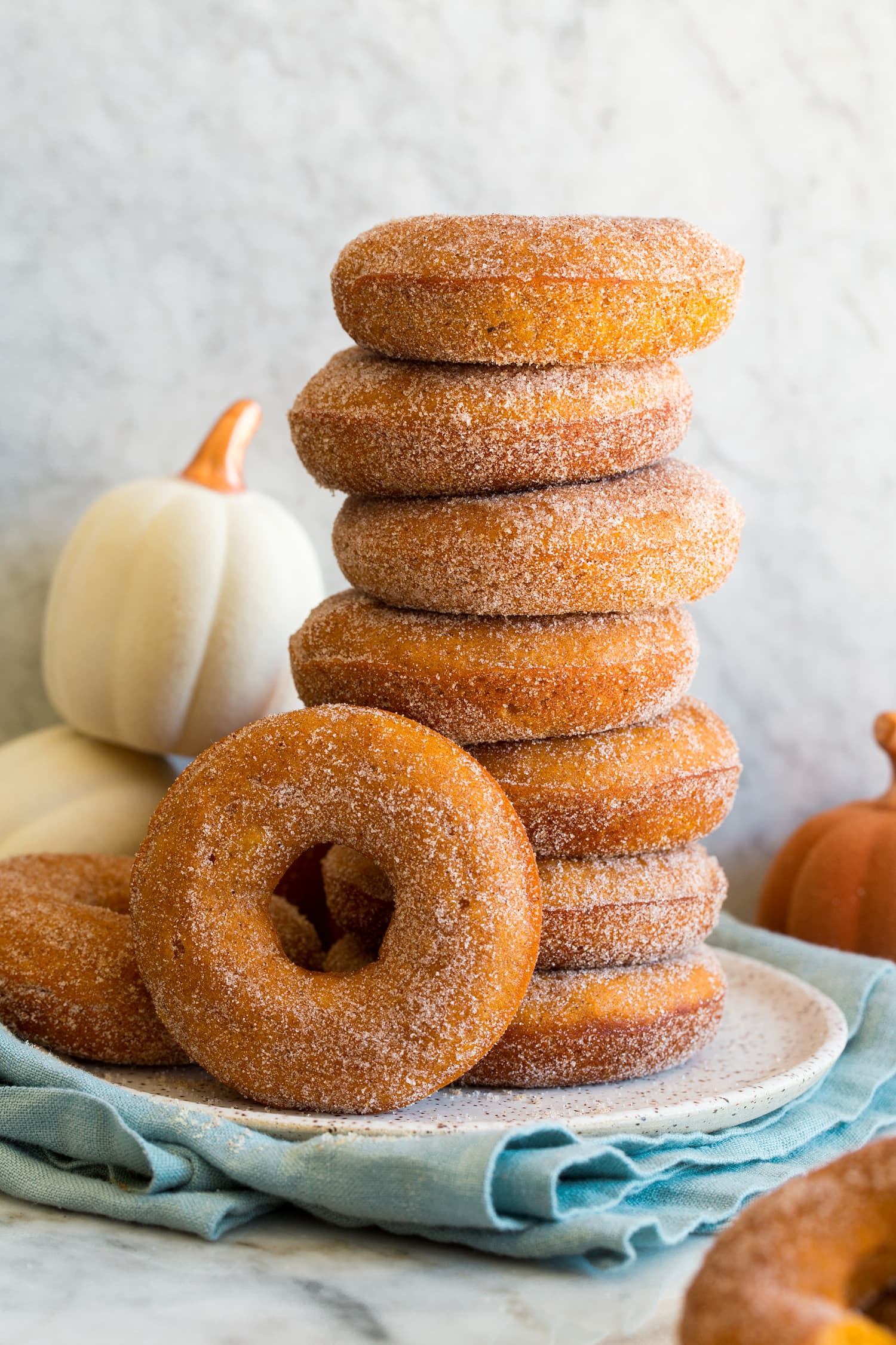 Pumpkin Donuts Stack of homemade baked pumpkin donuts covered in cinnamon sugar.