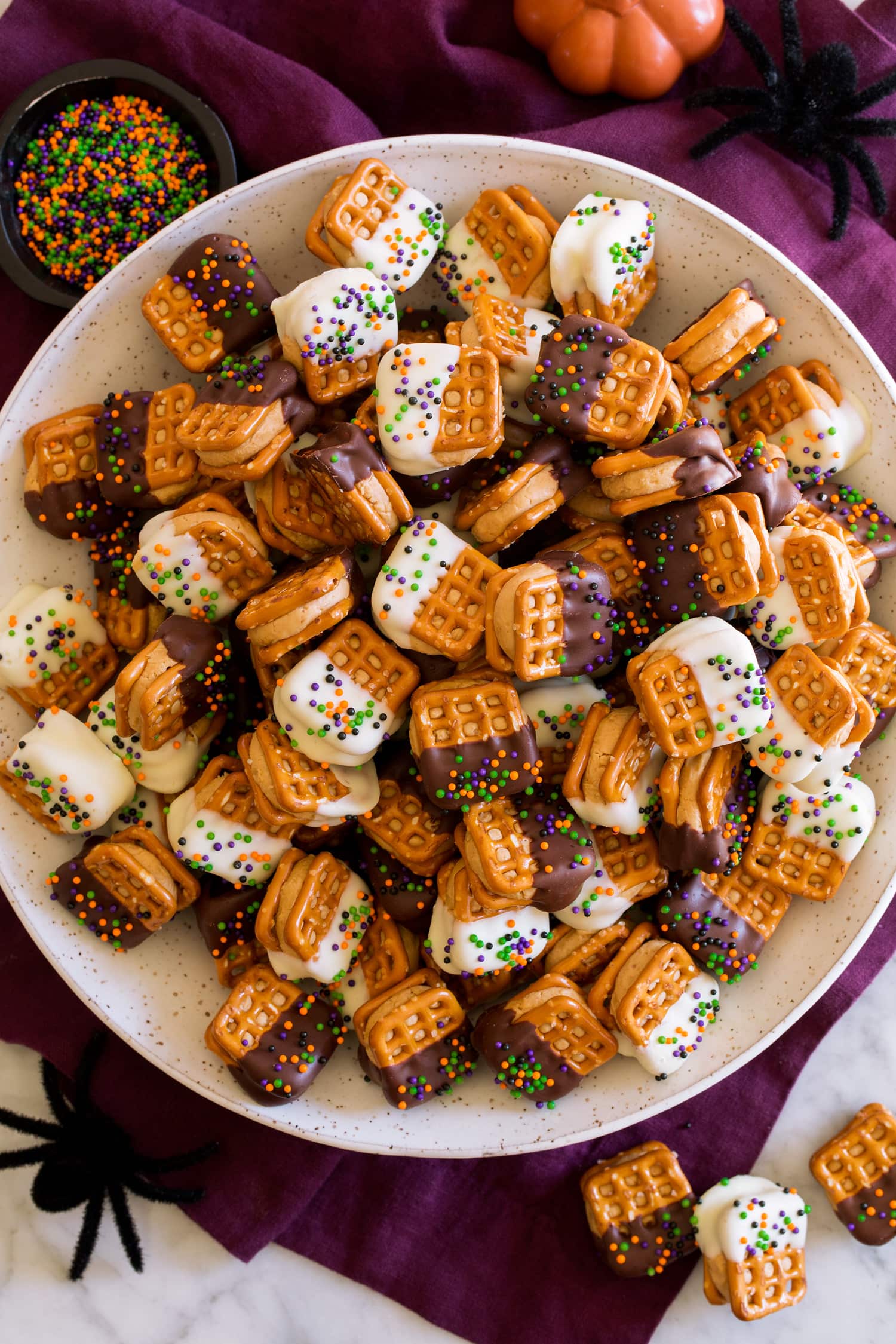 Chocolate Covered Peanut Butter Pretzel Bites Chocolate Covered Peanut Butter Pretzel Bites covered with white chocolate and dark chocolate and sprinkles.