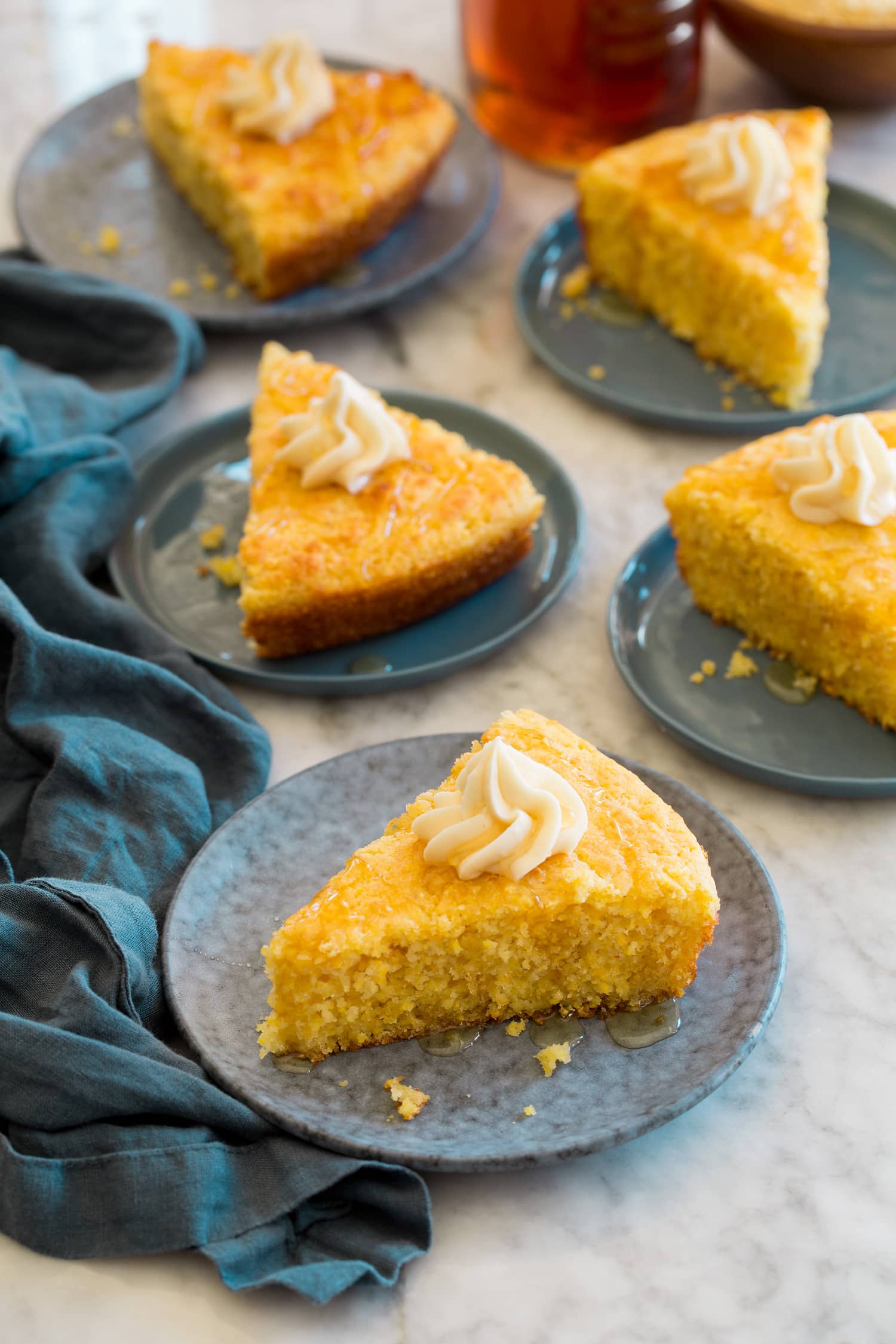 Southern Skillet Cornbread Five slices of skillet cornbread with honey and butter.