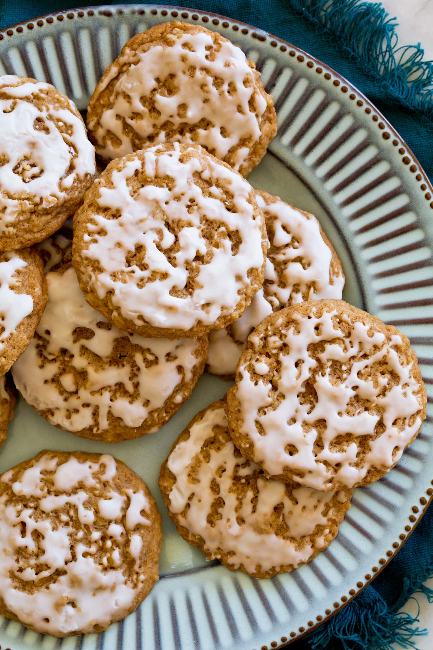 Iced Oatmeal Cookies Oatmeal cookies with vanilla icing on a turquoise plate.