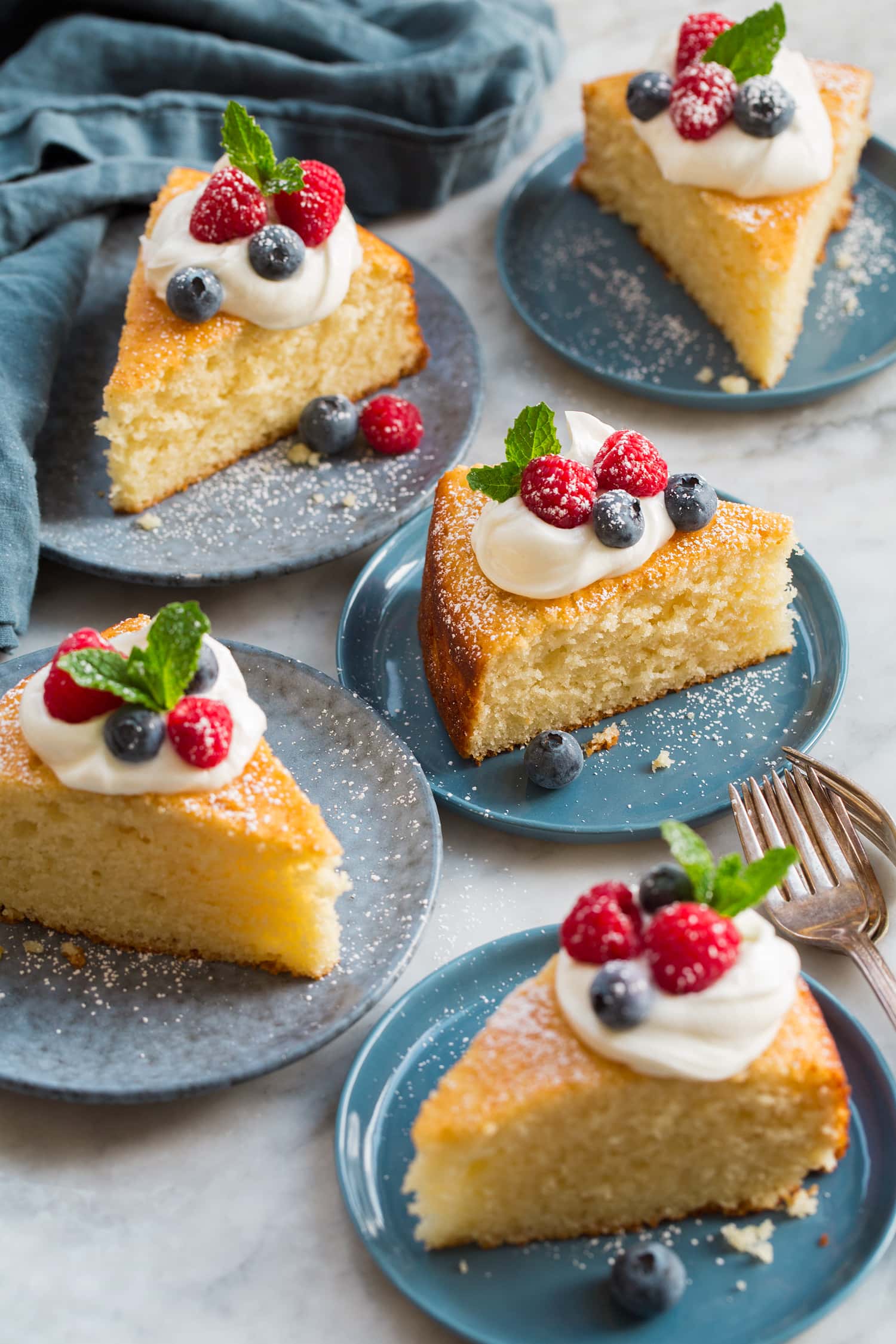 Yogurt Cake Five slices of yogurt cake shown on blue dessert plates.