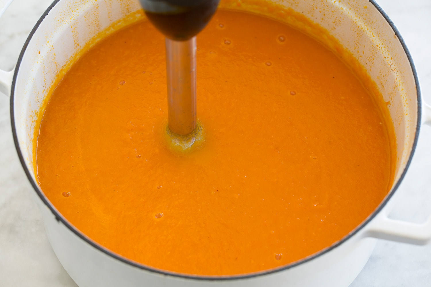 Carrot Soup Carrot soup being processed with an immersion blender.