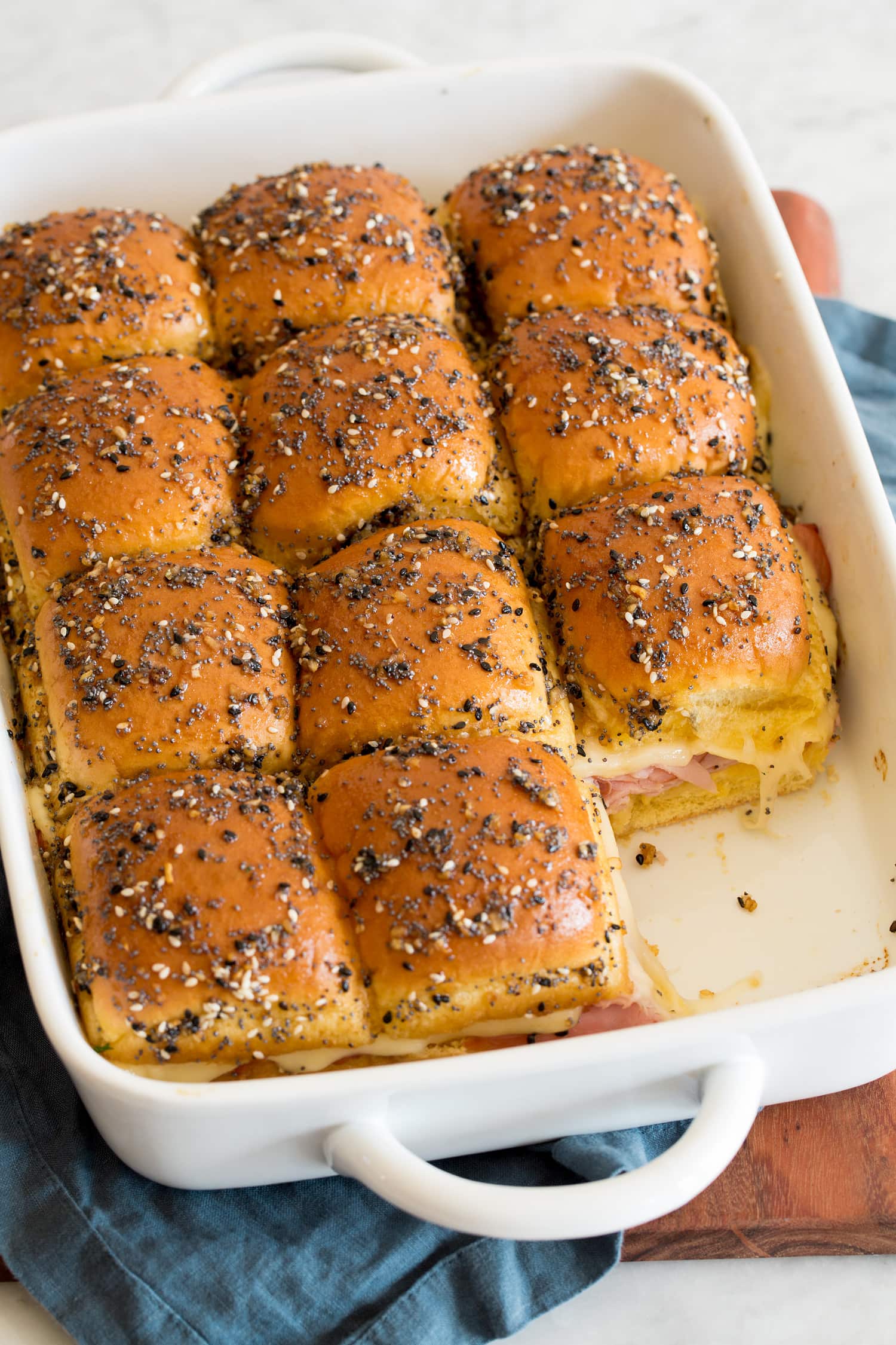 Ham and Cheese Sliders Ham and swiss cheese sliders shown after baking in baking dish with one removed.