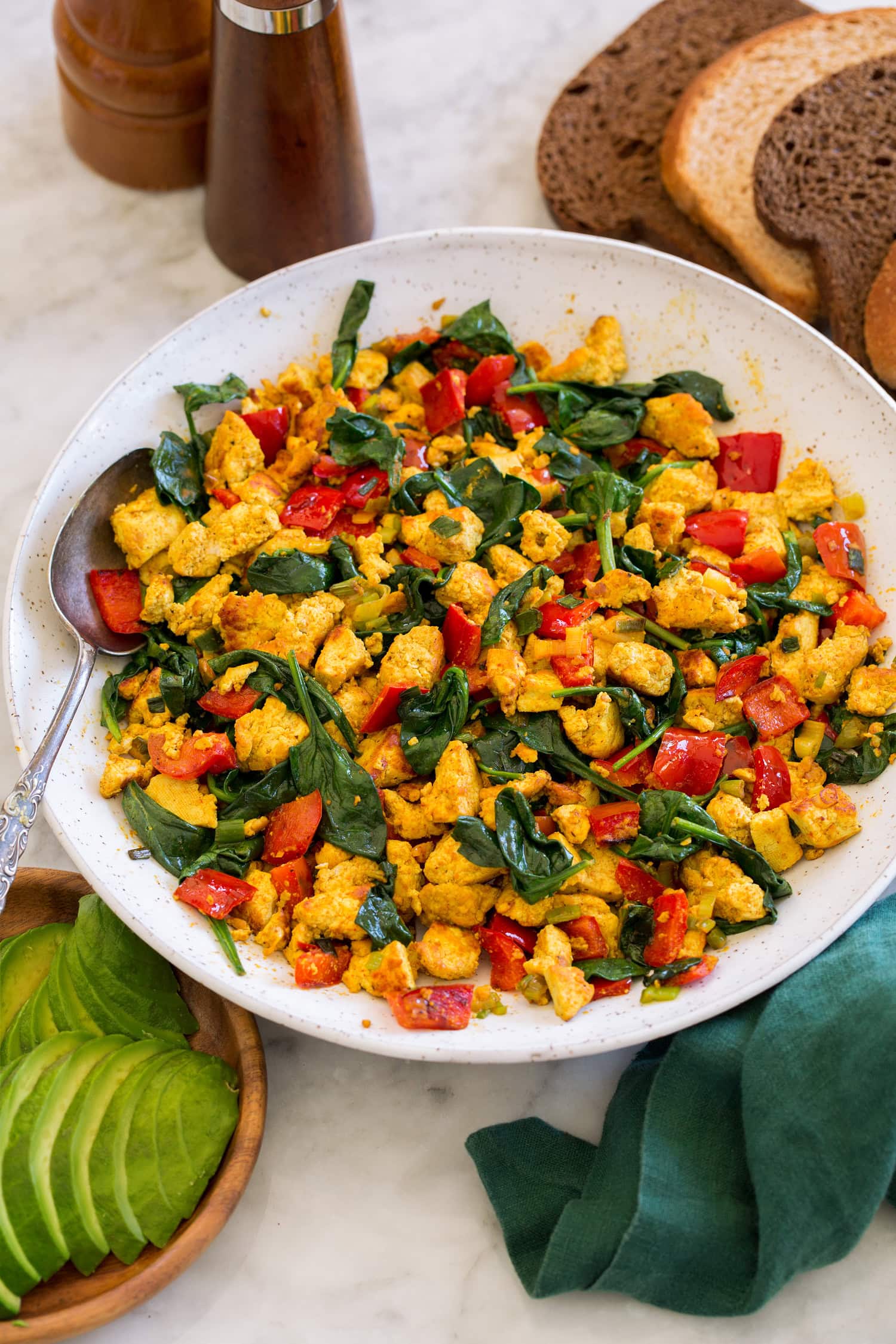 Tofu Scramble Tofu scramble in a white ceramic bowl over a marble surface with a green cloth to the side.