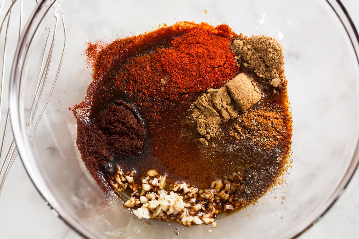 Tofu Tacos Mixing spice seasoning in a glass mixing bowl.