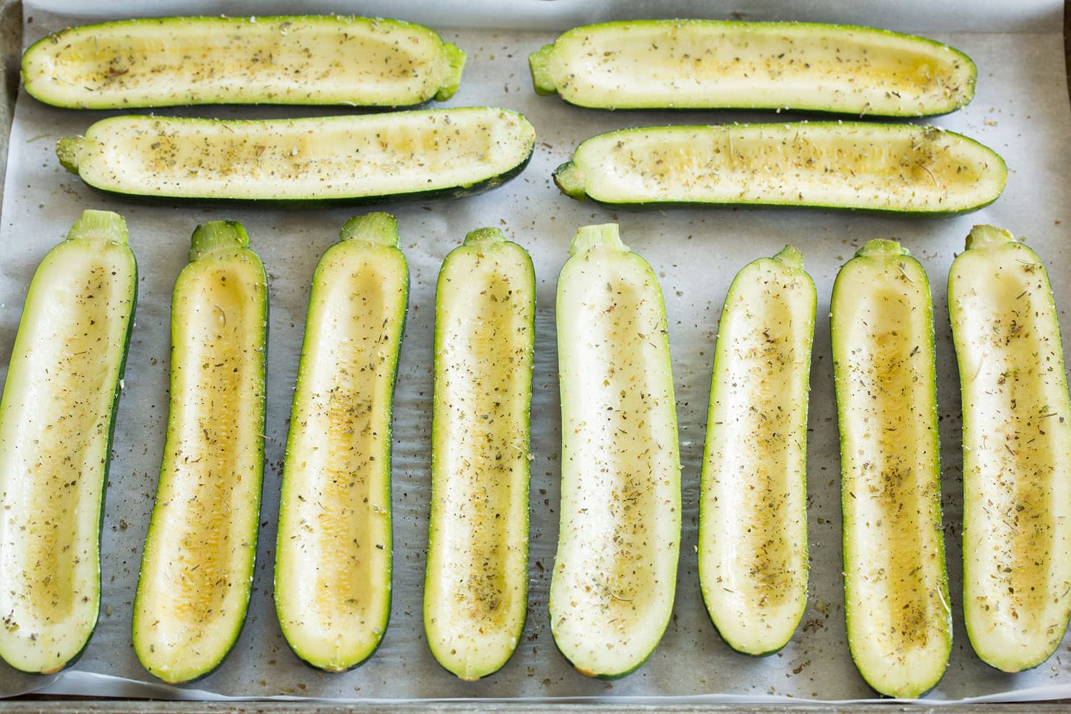 Zucchini Pizza Boats Zucchini boat halves on a baking sheet.