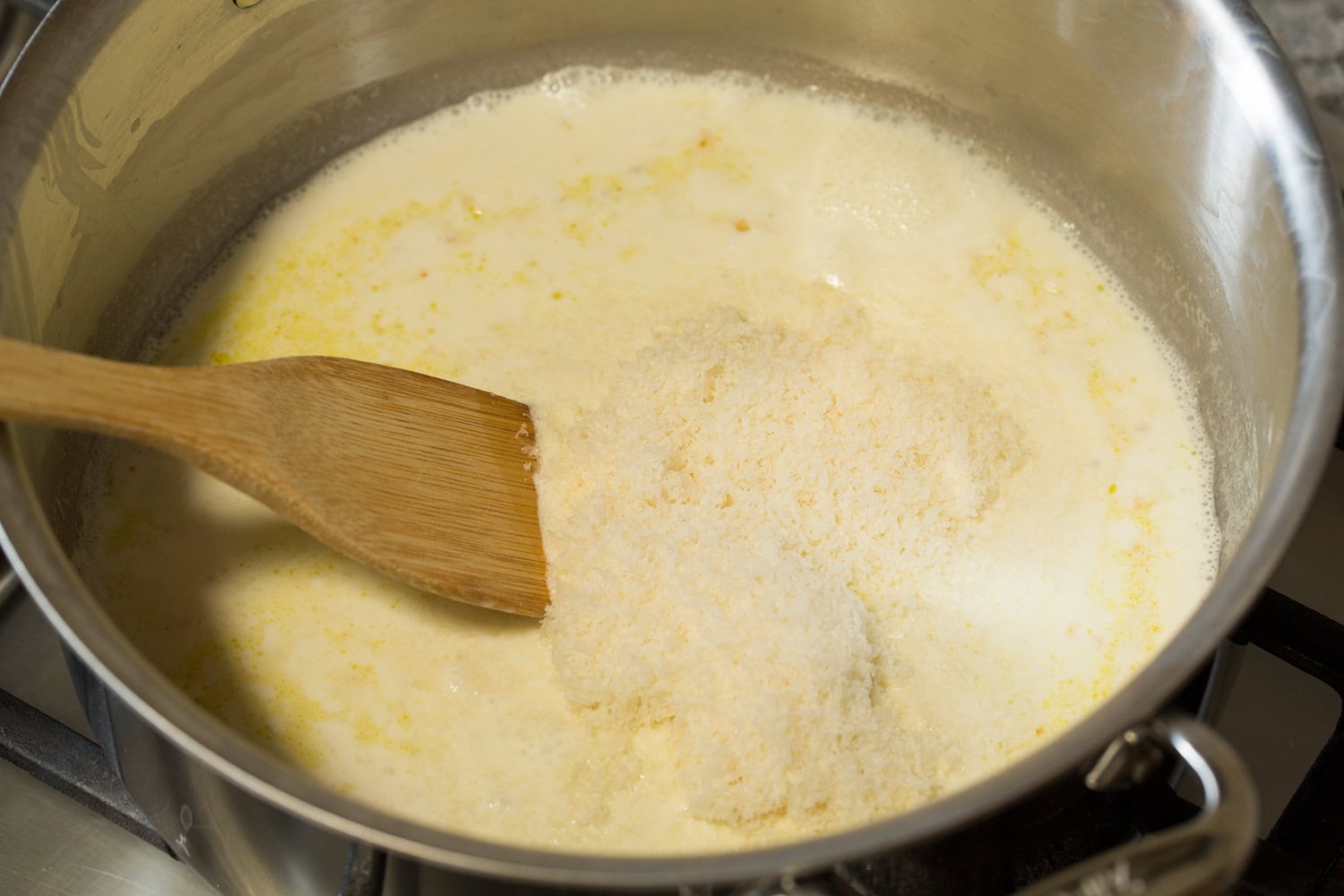 Creamy Pesto Pasta Cream and parmesan in a pot cooked together.