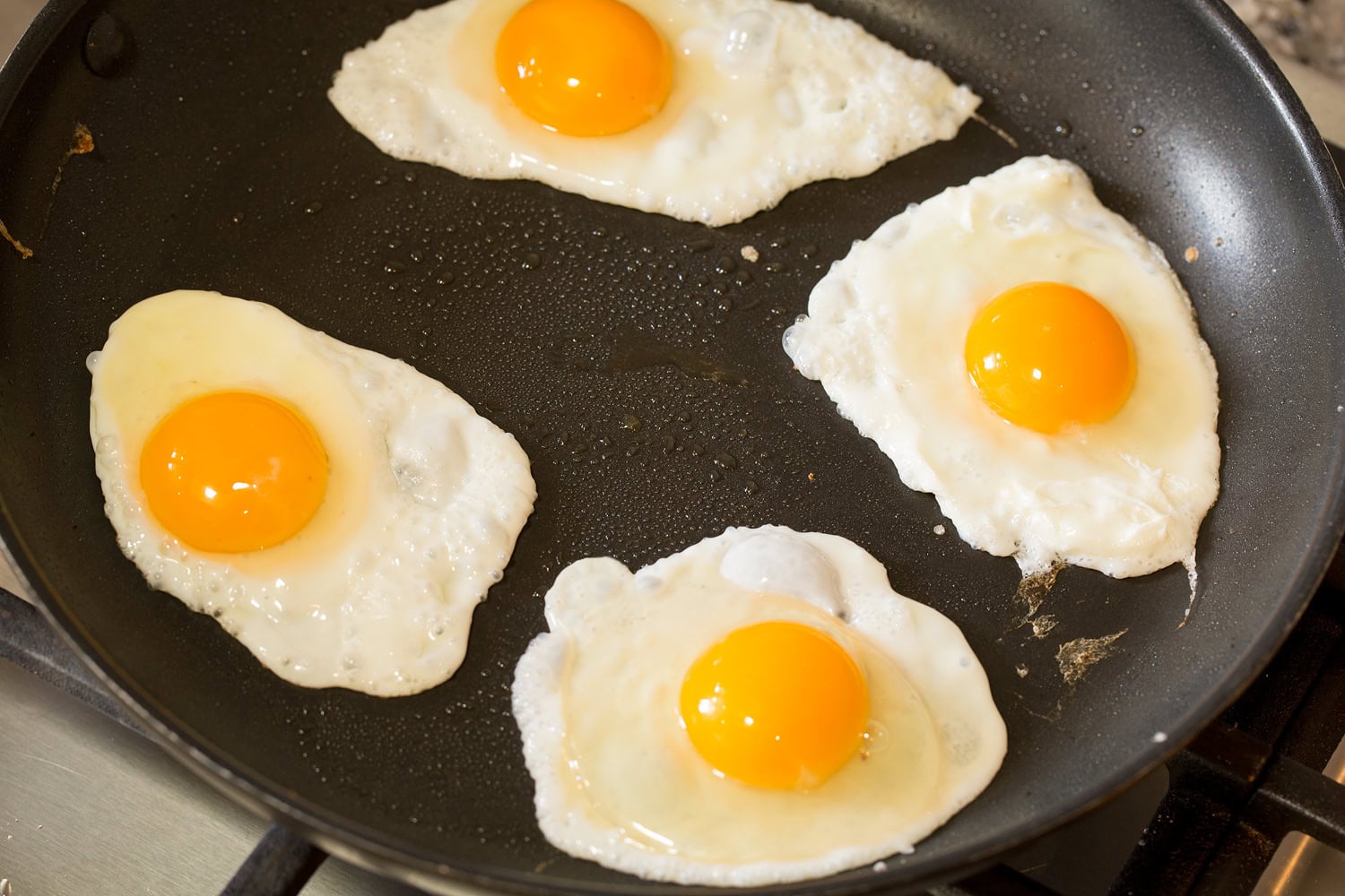 Huevos Rancheros Four fried eggs in a dark skillet.
