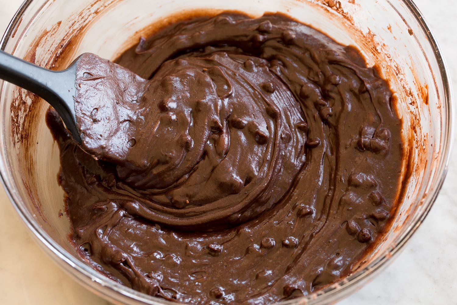 Brownie Bites Completed homemade brownie bite batter in a glass mixing bowl.