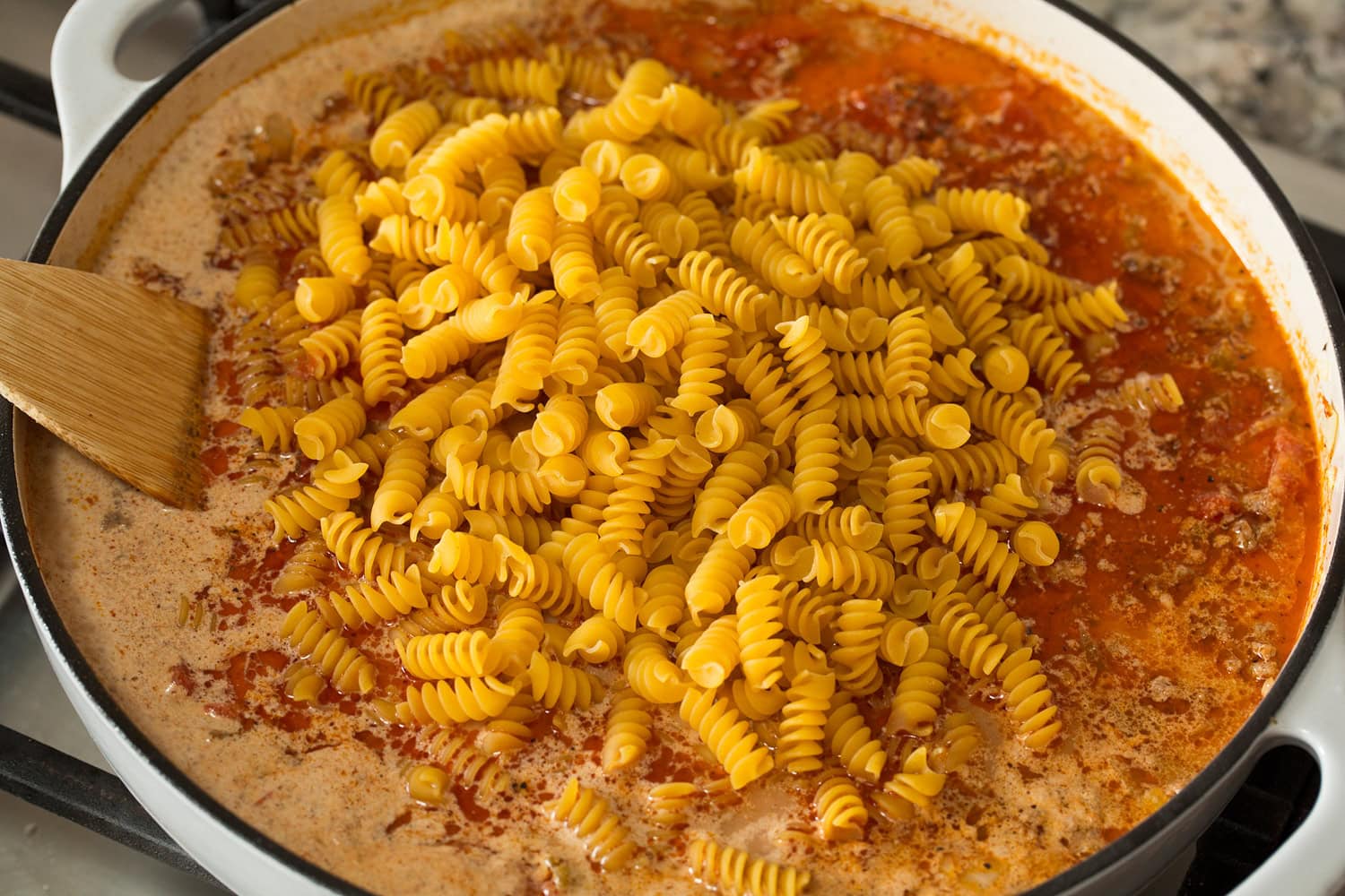 Taco Pasta Pasta added to broth, beef mixture in pan.