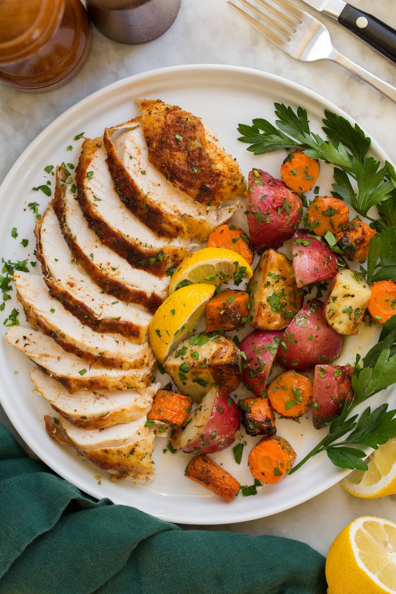 Spatchcock Chicken Sliced chicken with roasted vegetables to the side.