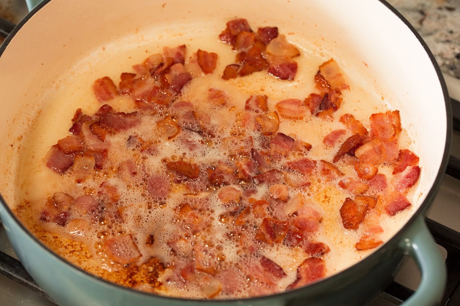 Beef Bourguignon Bacon pieces cooking in a pot.