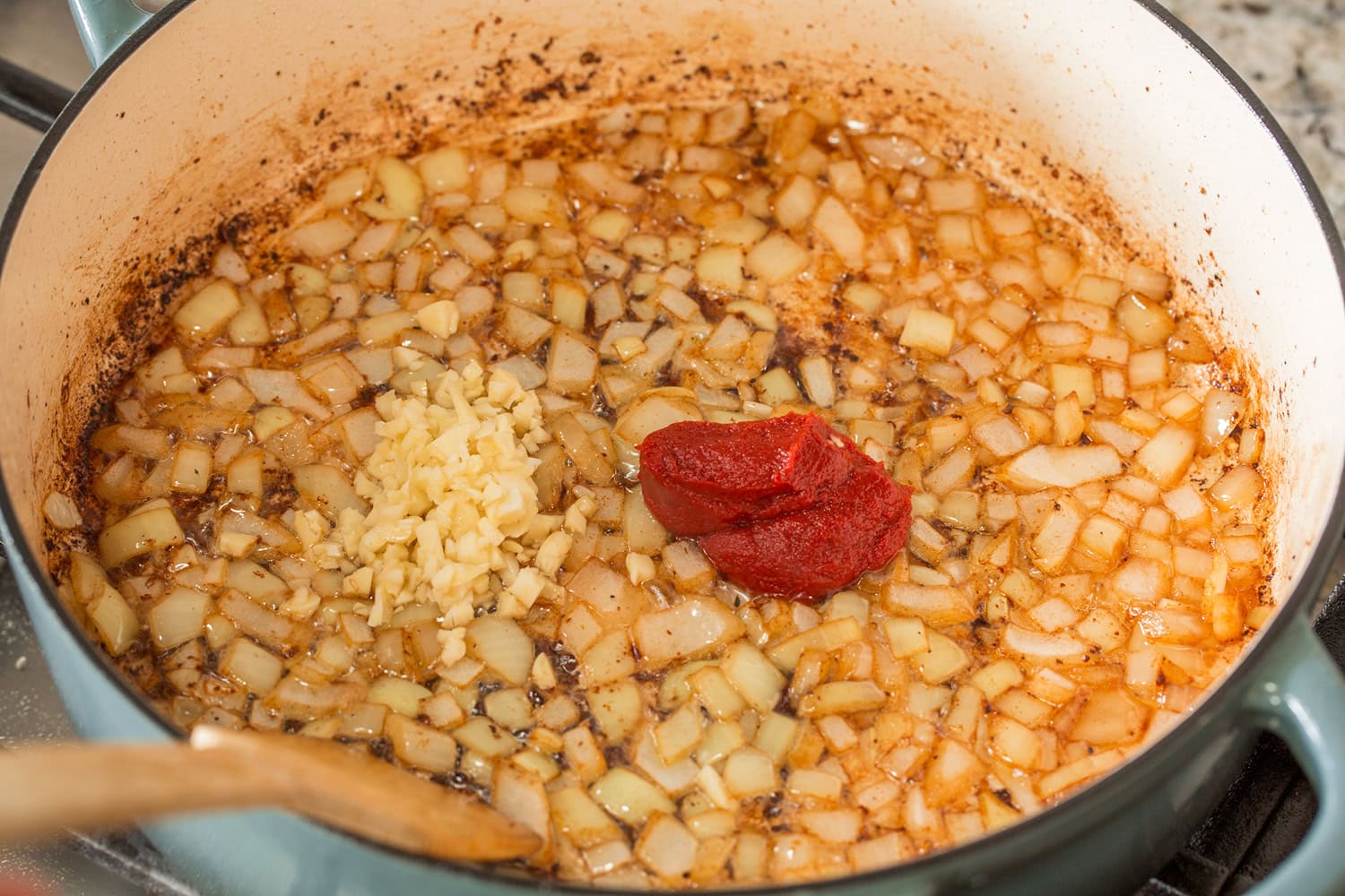 Beef Bourguignon Onion added to pot with tomato paste and garlic.