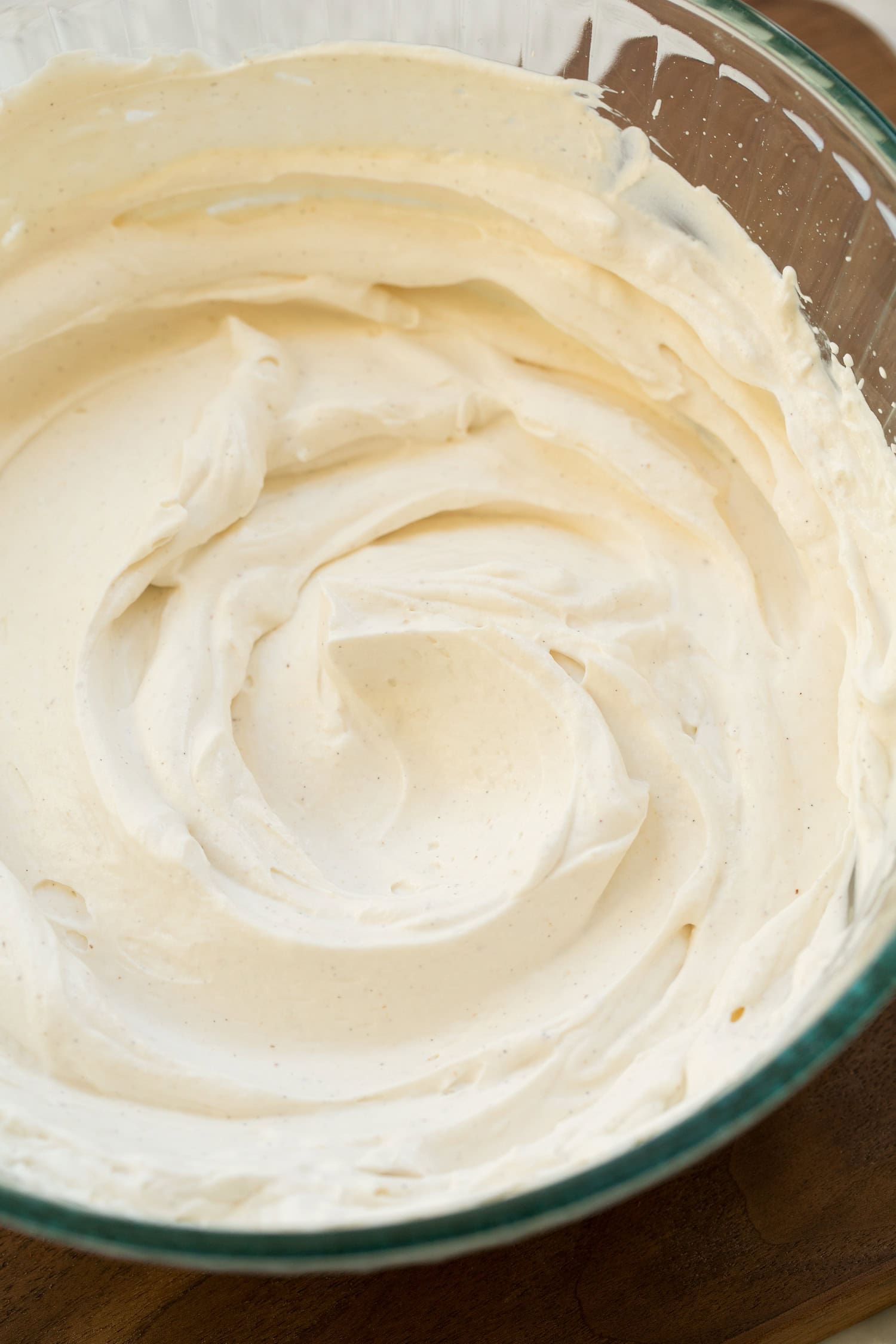 Whipped Greek Yogurt Completed fluffy whipped Greek yogurt in glass mixing bowl.