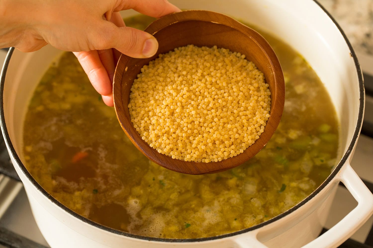 Italian Wedding Soup Adding acini di pepe pasta into soup.