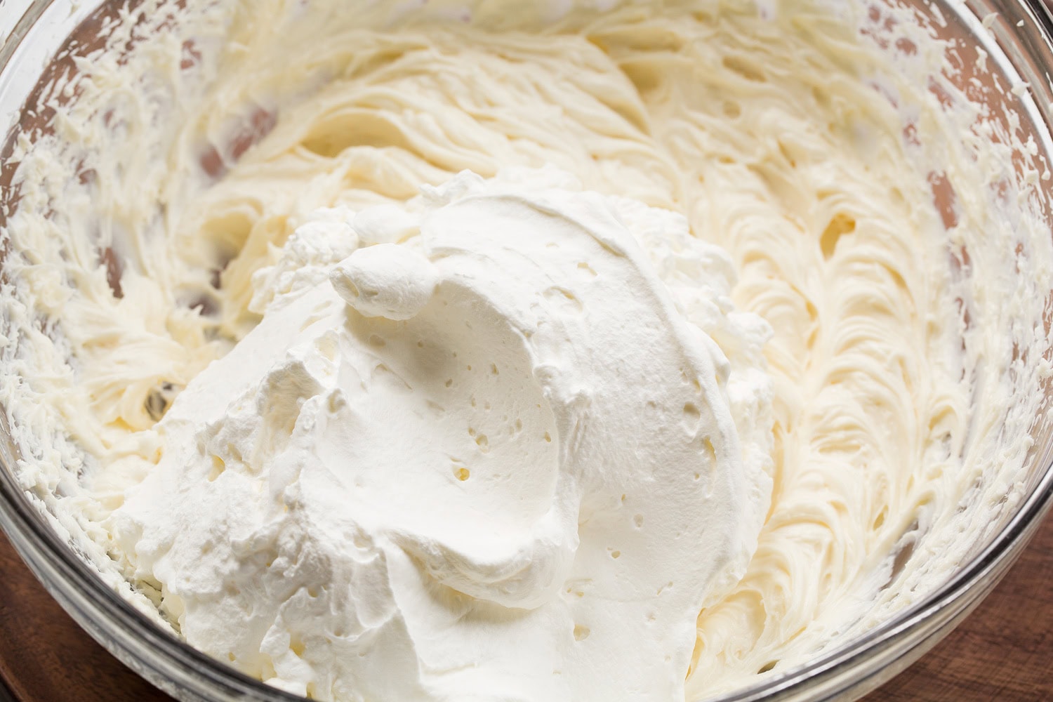 Strawberry Cheesecake Tiramisu Cream cheese and whipped cream added together in bowl.